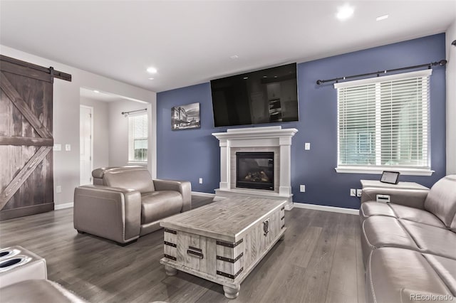 6990 E 132nd Pl, Thornton, CO 80602 - living room featuring dark wood finished floors, a barn door, a glass covered fireplace, and recessed lighting