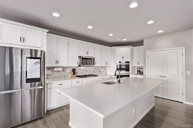 6990 E 132nd Pl, Thornton, CO 80602 - kitchen featuring stainless steel appliances, wood finished floors, decorative backsplash, light countertops, and white cabinetry