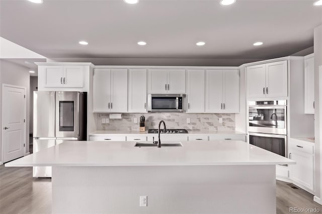 6990 E 132nd Pl, Thornton, CO 80602 - kitchen with stainless steel appliances, light countertops, white cabinetry, light wood-type flooring, and recessed lighting