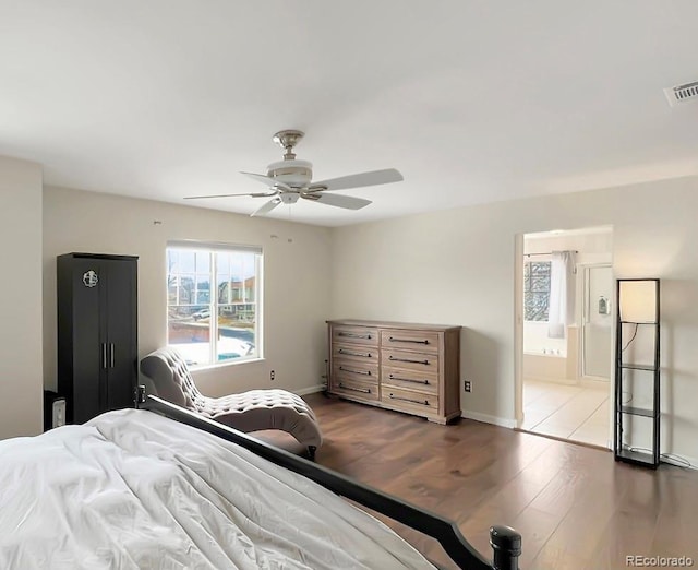 bedroom with ceiling fan, dark wood-type flooring, and ensuite bathroom