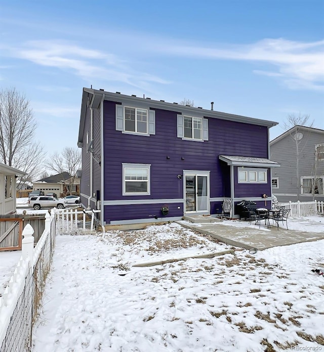 view of snow covered rear of property