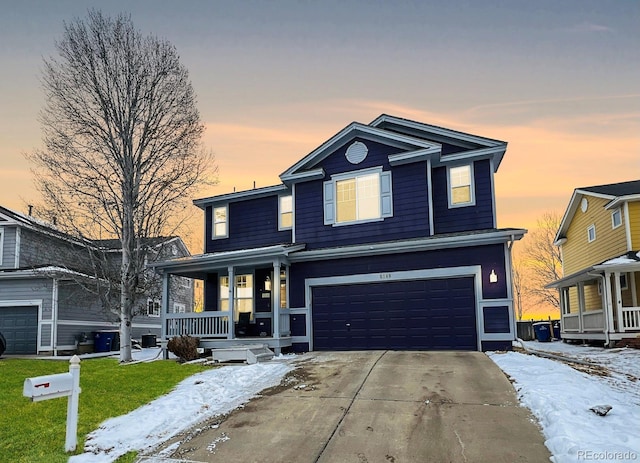 traditional home featuring a garage, covered porch, a lawn, and concrete driveway