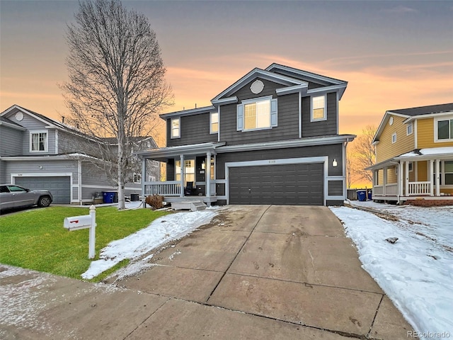 view of front of house featuring a front yard, an attached garage, covered porch, and driveway