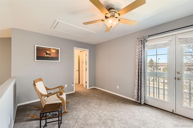 living area featuring a ceiling fan, baseboards, carpet, and attic access