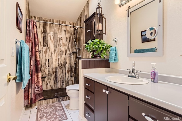 full bath with tile patterned flooring, a tile shower, toilet, and vanity