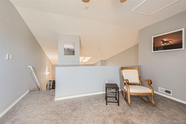 living area with visible vents, carpet floors, vaulted ceiling, and an upstairs landing