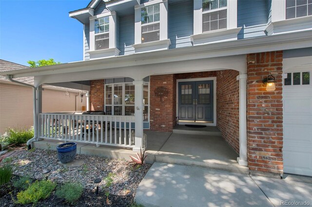 7773 Gunsight Pass, Littleton, CO 80127 - entrance to property with covered porch, brick siding, and french doors