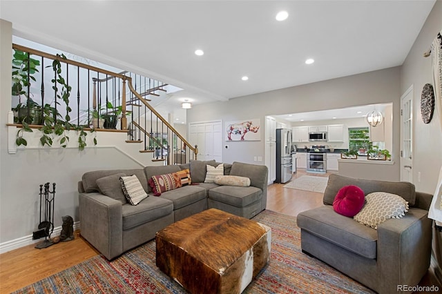 7773 Gunsight Pass, Littleton, CO 80127 - living room featuring light wood finished floors, stairway, recessed lighting, and baseboards