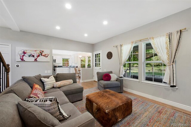 7773 Gunsight Pass, Littleton, CO 80127 - living room with light wood-type flooring, baseboards, recessed lighting, and stairway