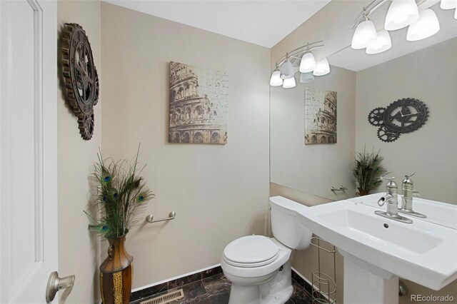 7773 Gunsight Pass, Littleton, CO 80127 - bathroom featuring toilet, baseboards, and marble look tiles