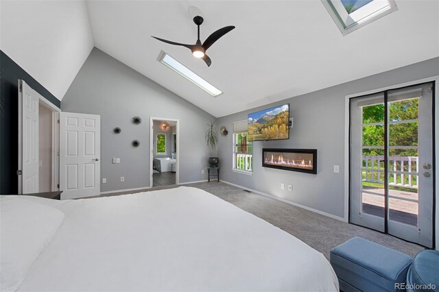 7773 Gunsight Pass, Littleton, CO 80127 - bedroom featuring a skylight, access to outside, carpet flooring, a glass covered fireplace, and baseboards