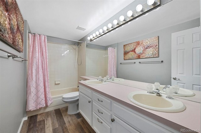 7773 Gunsight Pass, Littleton, CO 80127 - bathroom featuring double vanity, shower / bathtub combination with curtain, wood finished floors, and toilet
