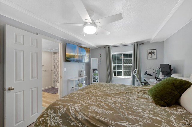7773 Gunsight Pass, Littleton, CO 80127 - bedroom featuring wood finished floors, a ceiling fan, a textured ceiling, and connected bathroom