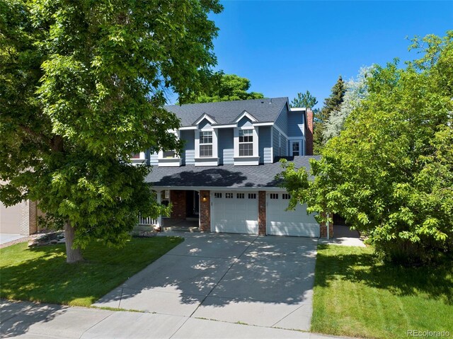 7773 Gunsight Pass, Littleton, CO 80127 - traditional-style house featuring concrete driveway, a front yard, a garage, and a shingled roof