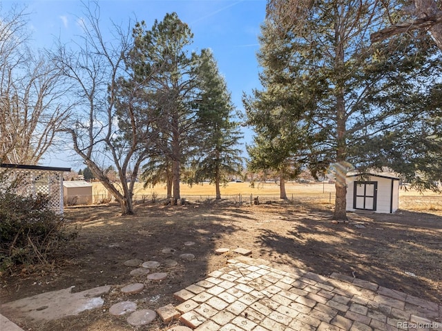 view of yard with a storage unit, an outdoor structure, and fence