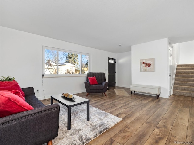 living area featuring stairs, wood finished floors, and baseboards