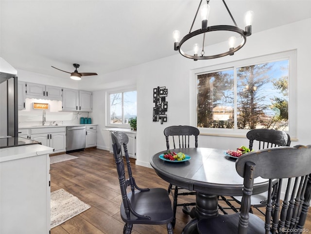 dining room with baseboards, dark wood-style flooring, and ceiling fan with notable chandelier