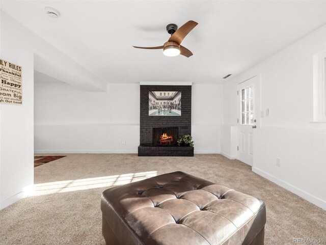 living room featuring visible vents, a ceiling fan, carpet floors, baseboards, and a brick fireplace