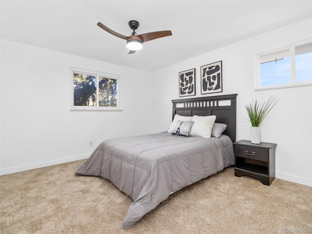 carpeted bedroom featuring baseboards and ceiling fan