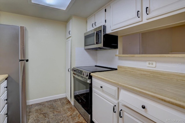 kitchen featuring white cabinetry, baseboards, light countertops, and appliances with stainless steel finishes