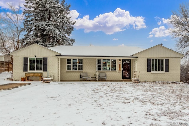 view of front of home featuring brick siding and fence