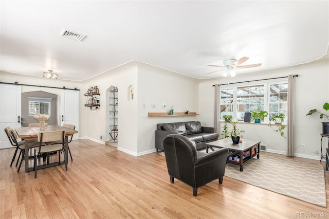 3865 Independence Ct, Wheat Ridge, CO 80033 - living room with ceiling fan, a barn door, light wood finished floors, baseboards, and visible vents