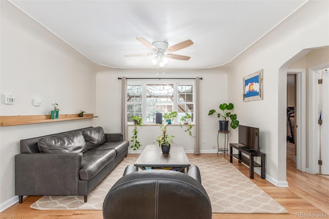 3865 Independence Ct, Wheat Ridge, CO 80033 - living room featuring arched walkways, baseboards, a ceiling fan, and light wood-style flooring