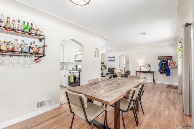 3865 Independence Ct, Wheat Ridge, CO 80033 - dining space featuring arched walkways, ceiling fan, visible vents, and light wood-style floors