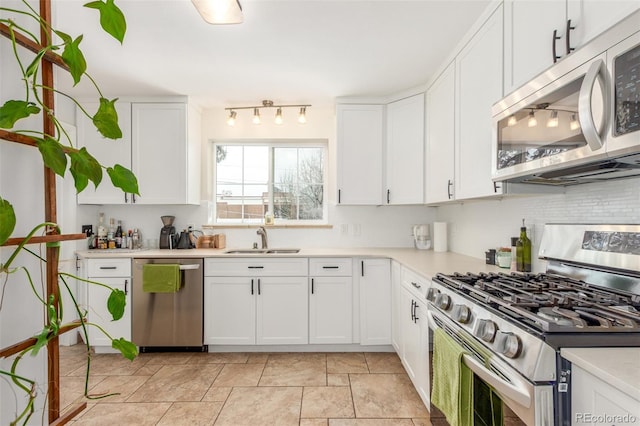 3865 Independence Ct, Wheat Ridge, CO 80033 - kitchen featuring white cabinets, appliances with stainless steel finishes, a sink, light countertops, and tasteful backsplash