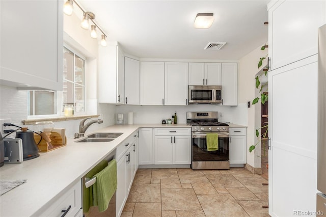 3865 Independence Ct, Wheat Ridge, CO 80033 - kitchen with a sink, appliances with stainless steel finishes, white cabinets, and light countertops