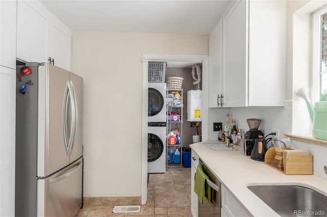 3865 Independence Ct, Wheat Ridge, CO 80033 - kitchen featuring light countertops, appliances with stainless steel finishes, stacked washer / drying machine, and water heater