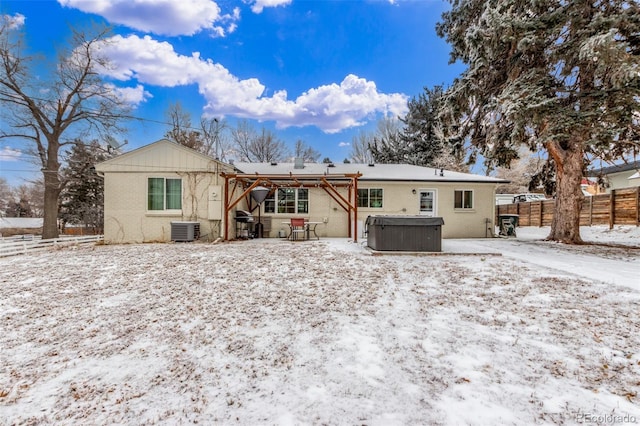 3865 Independence Ct, Wheat Ridge, CO 80033 - snow covered house with a patio, a fenced backyard, brick siding, central AC unit, and a hot tub