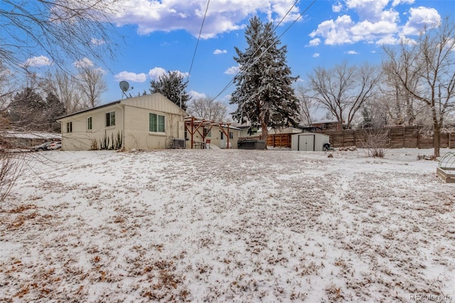 3865 Independence Ct, Wheat Ridge, CO 80033 - snow covered back of property featuring a storage shed, fence, and an outbuilding