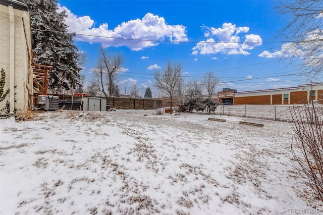 3865 Independence Ct, Wheat Ridge, CO 80033 - yard covered in snow with an outdoor structure, a fenced backyard, and a shed