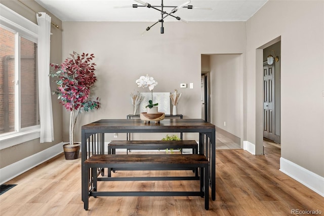 dining area featuring hardwood / wood-style flooring and a notable chandelier