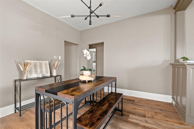 dining room with an inviting chandelier and light hardwood / wood-style flooring