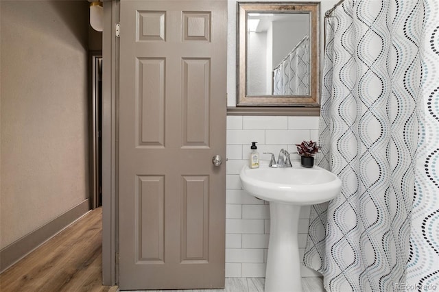 bathroom with curtained shower, hardwood / wood-style floors, and tile walls