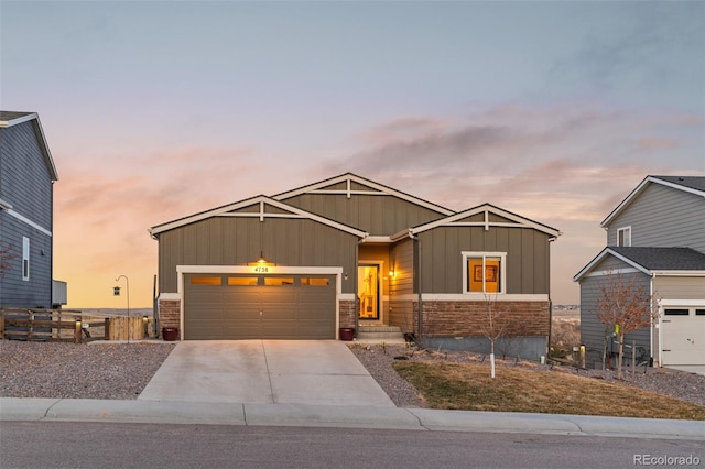 craftsman-style house with brick siding, board and batten siding, fence, a garage, and driveway