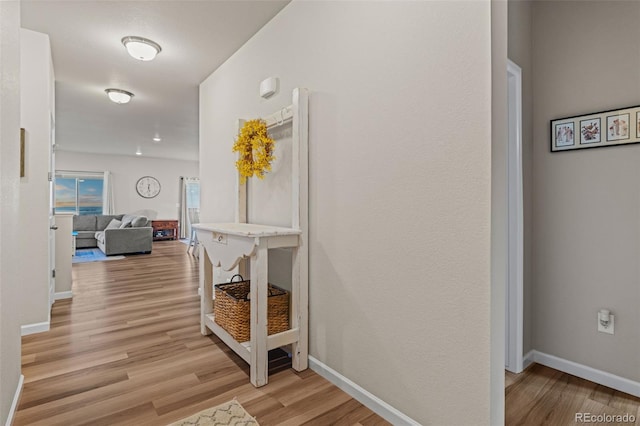 hallway with light wood finished floors and baseboards