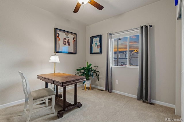 office space with light carpet, a ceiling fan, and baseboards