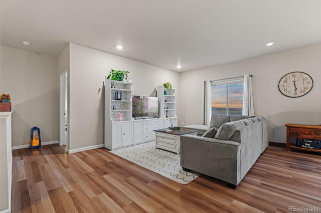 living area with recessed lighting, light wood-type flooring, and baseboards