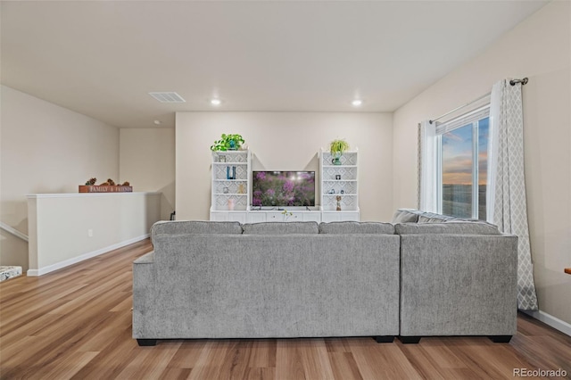 living area with recessed lighting, wood finished floors, visible vents, and baseboards