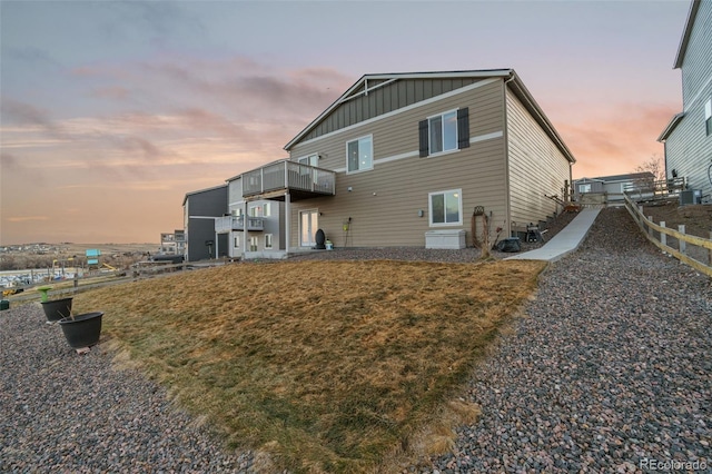 rear view of house with central AC and board and batten siding