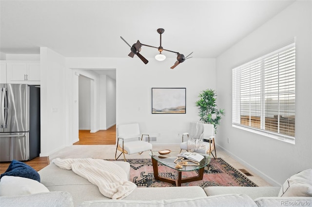 living room with light wood-type flooring and ceiling fan