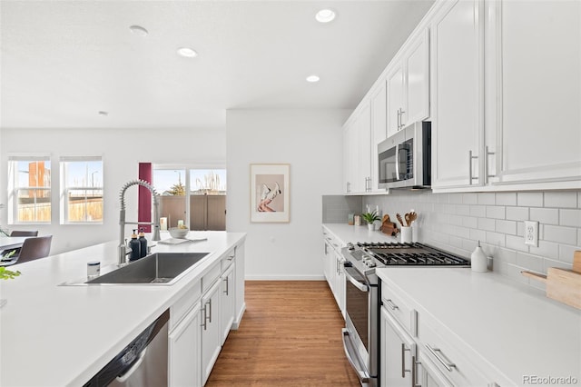 kitchen featuring white cabinetry, appliances with stainless steel finishes, sink, and backsplash