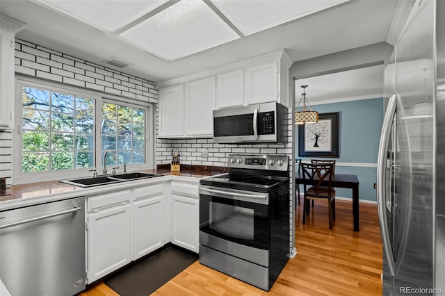 3767 E Phillips Cir, Centennial, CO 80122 - kitchen featuring appliances with stainless steel finishes, a sink, backsplash, white cabinets, and light wood-style floors