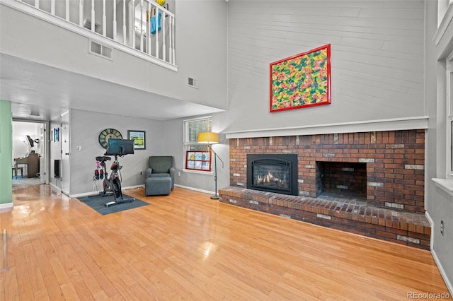 3767 E Phillips Cir, Centennial, CO 80122 - living area with a fireplace, wood finished floors, baseboards, and a high ceiling