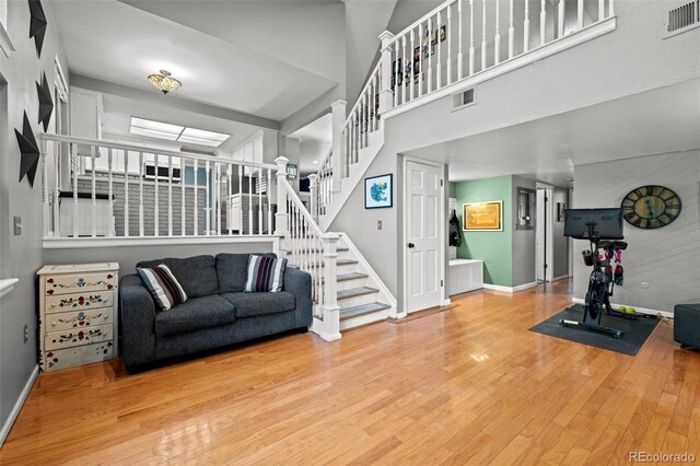 3767 E Phillips Cir, Centennial, CO 80122 - living area featuring wood finished floors, baseboards, stairway, and a towering ceiling