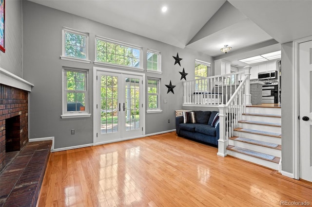 3767 E Phillips Cir, Centennial, CO 80122 - unfurnished living room featuring stairway, hardwood / wood-style floors, a fireplace, baseboards, and high vaulted ceiling