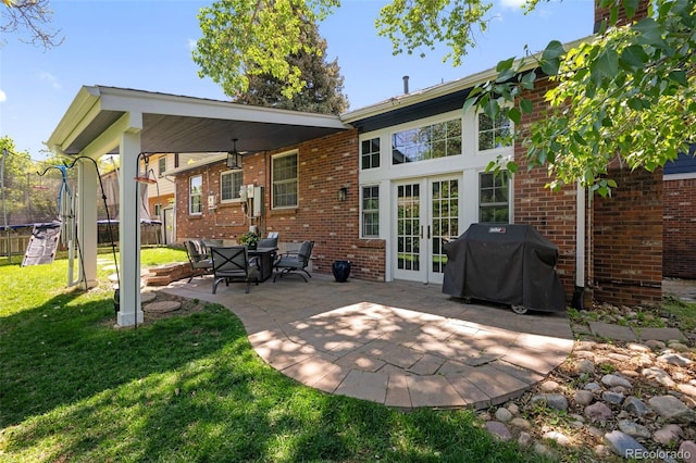 3767 E Phillips Cir, Centennial, CO 80122 - rear view of property featuring french doors, a patio, brick siding, and a trampoline